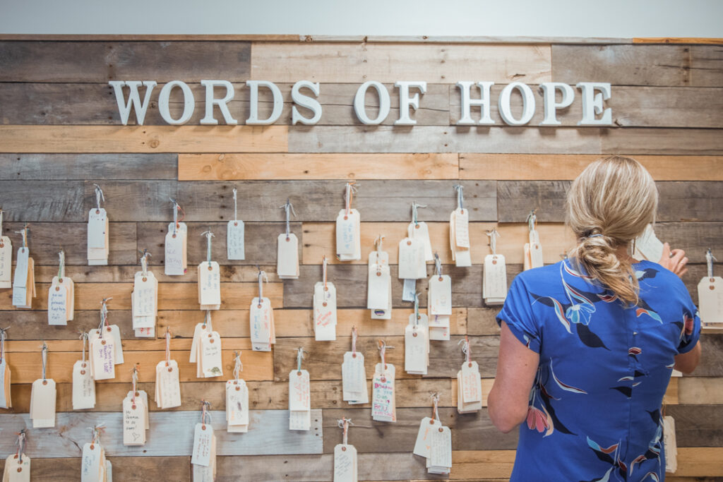 Woman putting inspirational quotes on wall.
