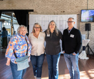 Group of people posing together and smiling. 