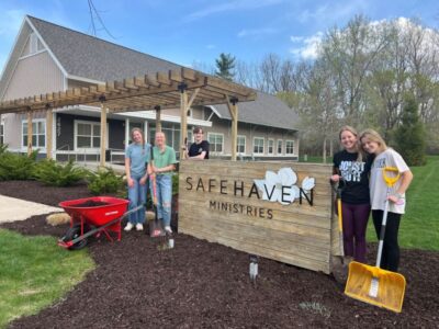 Group of Safe Haven volunteers outside helping with landscaping around the office
